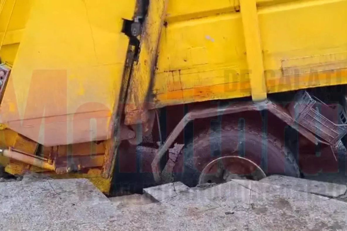 O mașină de gunoi a căzut într-o groapă după ce drumul s-a surpat